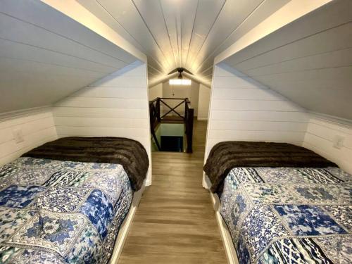 una camera con due letti in mansarda di Rustic Elegance 3BDR Stylish Farmhouse Getaway a Schenectady