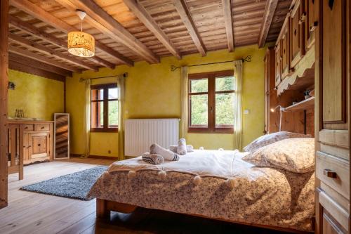 a bedroom with a large bed in a room with yellow walls at la maison des cerries in Hautecour