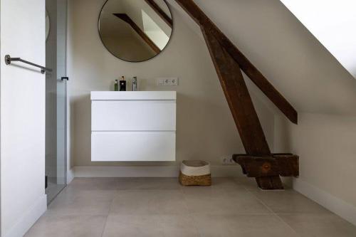 ein Badezimmer mit einem Spiegel an der Wand und einem Waschbecken in der Unterkunft Park Lofts Groningen Penthouse in Groningen