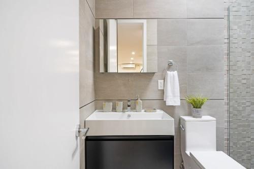 uma casa de banho com um lavatório branco e um espelho. em 78-4A 2BR Duplex with a Balcony Prime UES em Nova York