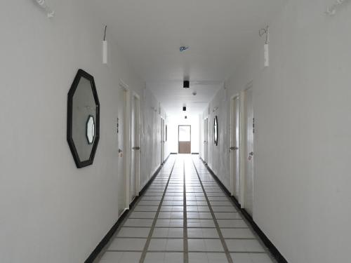 a hallway with white walls and a mirror on the wall at RoomQuest IT Square Don Mueang Airport in Bangkok