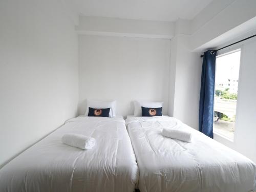 two beds sitting next to each other in a room at RoomQuest IT Square Don Mueang Airport in Bangkok