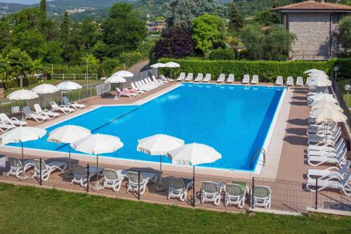 an overhead view of a swimming pool with chairs and umbrellas at Appartamenti San Carlo in Costermano