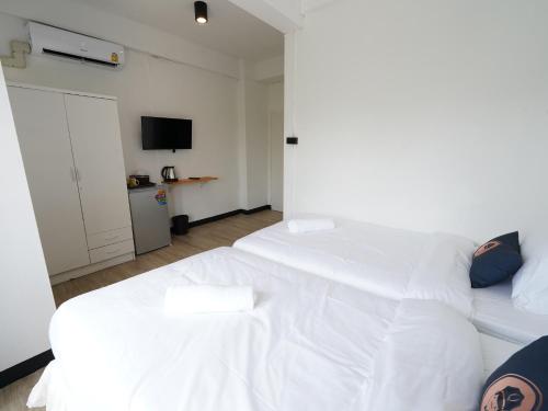 a bedroom with two white beds and a television at RoomQuest IT Square Don Mueang Airport in Bangkok