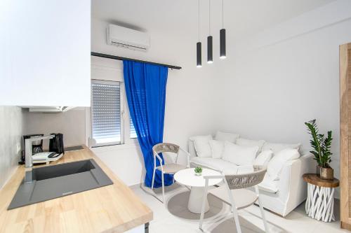a living room with a white couch and a table at Georgia apartments in town in Skiathos Town
