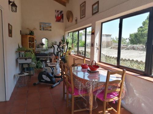 une salle à manger avec une table, des chaises et des fenêtres dans l'établissement Villa chaleureuse avec piscine, à Saint-Alexandre