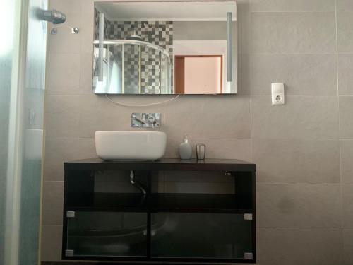 a bathroom with a sink and a mirror at Retiro das Bananeiras in Horta
