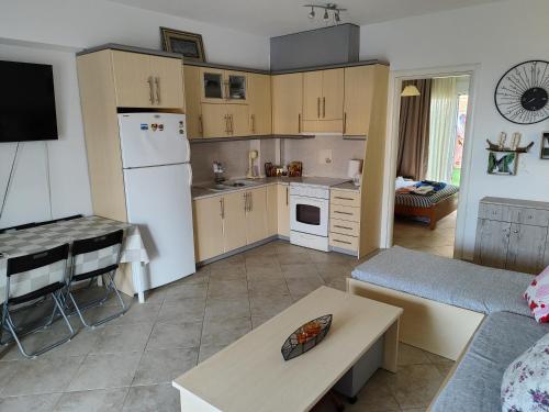 eine Küche und ein Wohnzimmer mit einem Kühlschrank und einem Tisch in der Unterkunft ΛΕΛΑ in Kriopigi