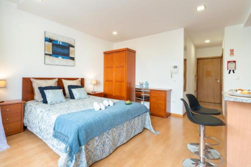 a bedroom with a bed and a desk and a chair at Host Wise - Bright Quiet Flats - Prime Location in Porto