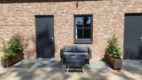a chair sitting in front of a brick building at B en B Stipdonk in Lierop