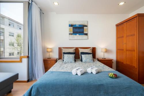 a bedroom with a blue bed with two towels on it at Host Wise - Bright Quiet Flats - Prime Location in Porto
