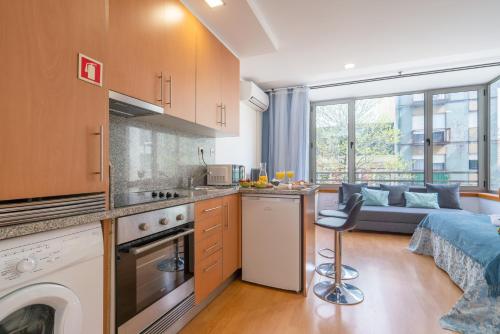 a kitchen and a living room with a couch at Host Wise - Bright Quiet Flats - Prime Location in Porto