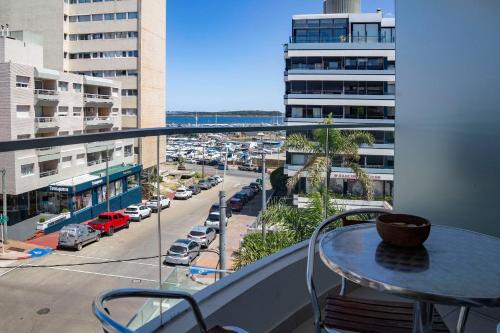 balcón con mesa y vistas a la calle en Oceana Suites en SeaPort, vista al mar, en Punta del Este
