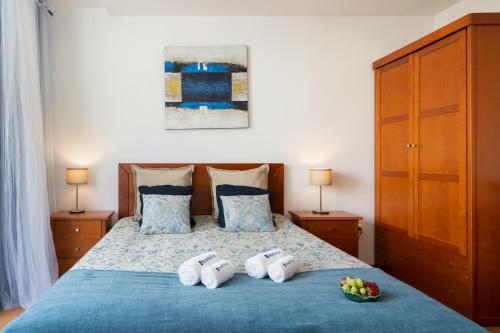 a bedroom with a blue bed with a bowl of fruit on it at Host Wise - Bright Quiet Flats - Prime Location in Porto