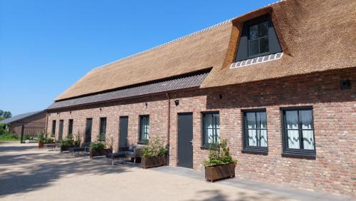a large brick building with a large roof at B en B Stipdonk in Lierop