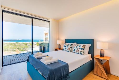 1 dormitorio con 1 cama y vistas al océano en Pé n'Areia - Apartamento com Vista mar, en Praia da Barra