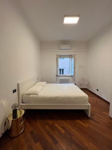 a bedroom with a white bed and a window at Appartamento del Duca in Senigallia