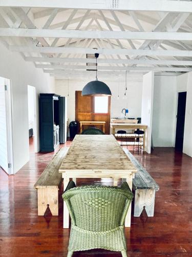 a large wooden table in a room with a kitchen at Loft on Long in Hermanus