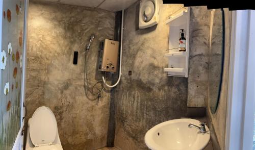 a small bathroom with a toilet and a sink at อีต่องโฮมสเตย์ in Thong Pha Phum