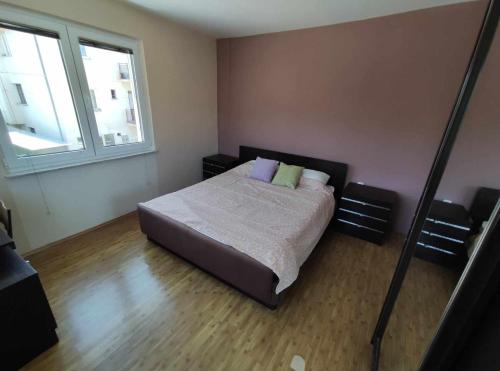 a bedroom with a bed and two windows at Cozy Apartment Palazzo in Ohrid