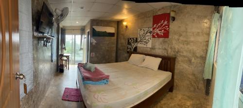 a bedroom with a bed with a laptop on it at อีต่องโฮมสเตย์ in Thong Pha Phum