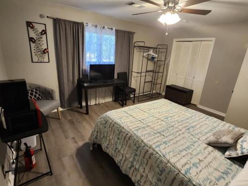 Dormitorio con cama, escritorio y TV en Monticello BnB, en North Little Rock