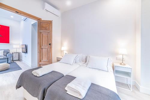 1 dormitorio blanco con 2 camas en una habitación en AlohaMundi Segovia&Fortaleza, en Sevilla