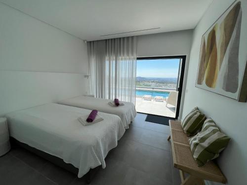 a hotel room with two beds and a view of the ocean at villagoldra rentals - Luxury and Family Villa in Goldra de Baixo
