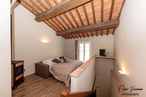 a bedroom with a bed and a wooden ceiling at La casa delle Rondini in Forcoli