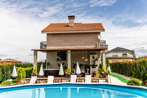 una villa con piscina e una casa di Casa Victoria garden con Jacuzzi y piscina a Caldas de Reis