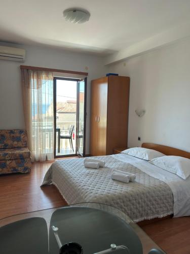 ein Schlafzimmer mit einem großen Bett und einem Balkon in der Unterkunft Apartmani Baki in Podstrana
