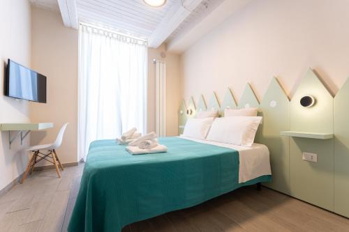 a bedroom with a large bed with a blue blanket at Oceano Rooms in Termoli