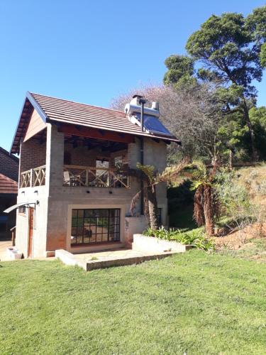 a house with a grassy yard in front of it at Kaltenbach Cottages in Magoebaskloof