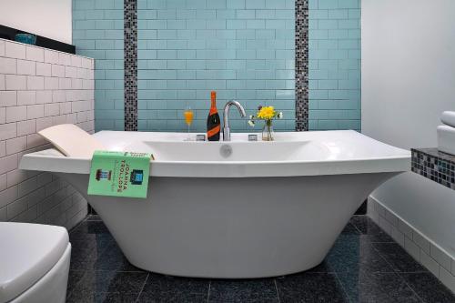 a bathroom with a tub and a toilet and a sink at Finest Retreats - Skyview Lodge in Eglwys-Fâch