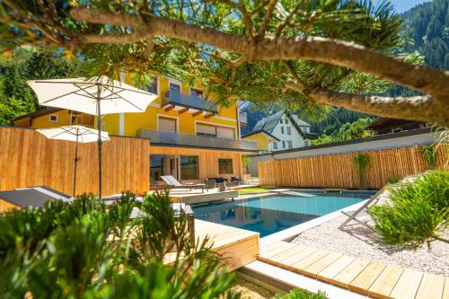 ein Haus mit einem Pool und einem Haus in der Unterkunft AlpinSpa zur Post in Bad Gastein