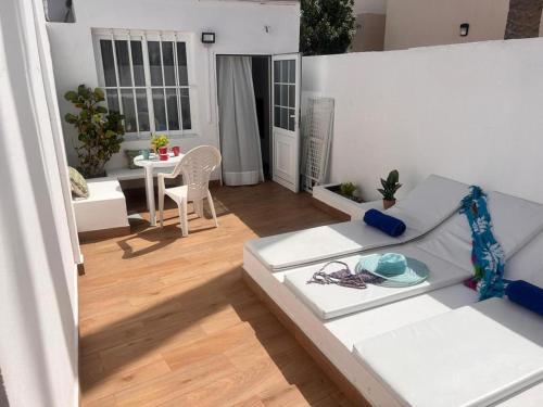 sala de estar con sofá blanco y mesa en Estudio Kivi, en Corralejo