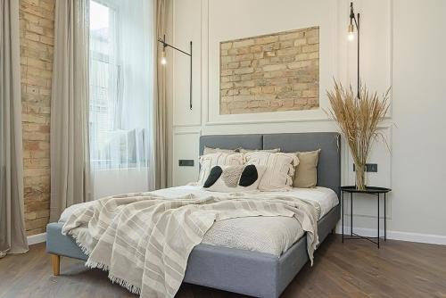 a bedroom with a bed with a brick wall at FREE PARKING Old Town Central Station Apart with Balcony in Vilnius