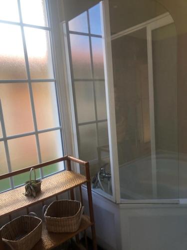 La salle de bains est pourvue d'une baignoire et d'une table avec des paniers. dans l'établissement Villa Thomas, à Arcachon