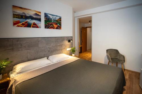 - une chambre avec un grand lit et une chaise dans l'établissement Hotel Ridomar 365, à Lloret de Mar