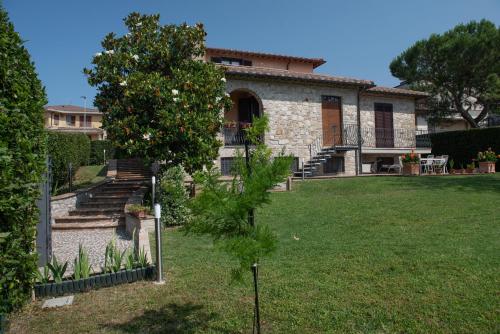 an old stone house with a tree in the yard at Dolce Alba in Montecastrilli
