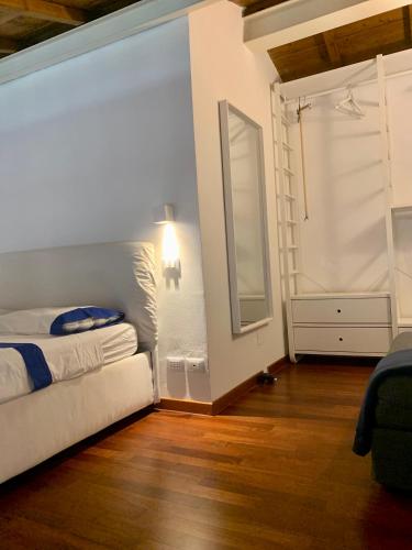 a bedroom with a bed and a mirror on the wall at Regina Elena, Luminoso appartamento sulla spiaggia in Calambrone