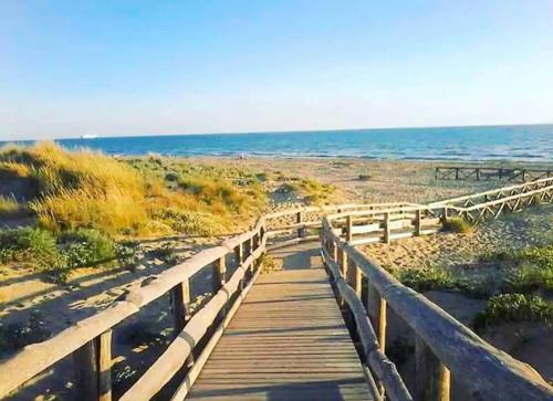 a wooden boardwalk leading to a beach with the ocean at Regina Elena, Luminoso appartamento sulla spiaggia in Calambrone