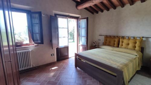 a bedroom with a bed in a room with windows at Il poggio più 'n giù in Volterra