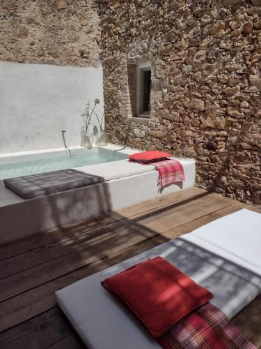 a bathroom with a bath tub and a stone wall at CAN TANDO Restored catalan old barn to enjoy peaceful rural simplicity in Sant Jordi Desvalls