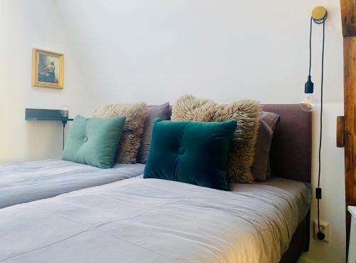 - un lit avec des oreillers bleus et bruns dans l'établissement Betty Blue Bed & Breakfast, à Gouda