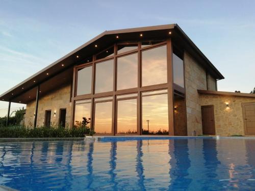 uma casa com uma piscina em frente em Casa Albarari Boutique Double Rooms with access to shared Infinity Pool em Sanxenxo