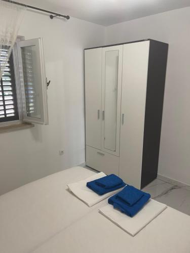 biały pokój z 2 niebieskimi ręcznikami na podłodze w obiekcie Holiday Home 1 w Bibinje