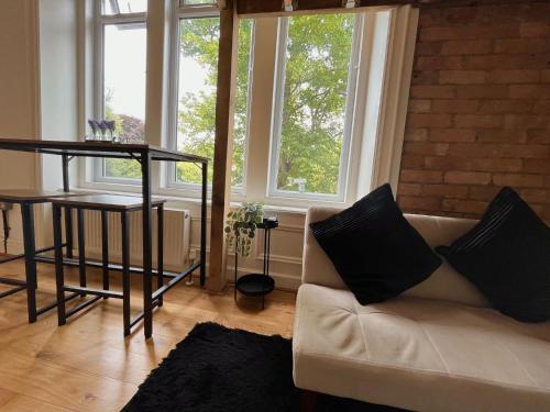 a living room with a couch and a table and windows at Flat 14, 10 St John’s in Bournemouth
