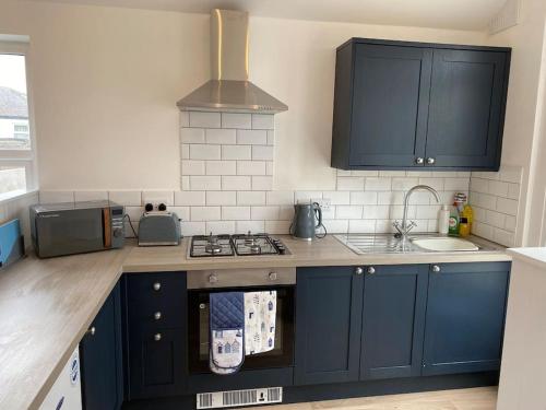 a kitchen with blue cabinets and a stove top oven at The Old Warehouse in Blackpool