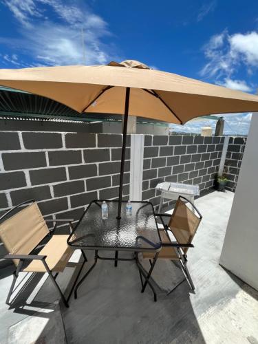 a table and chairs under an umbrella on a patio at Casa Vacacional Maya in Comitán de Domínguez